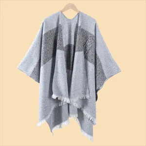 Detail eines Strick-Ponchos mit Farblöcken, weicher Kaschmir-Haptik und Fransen am Saum