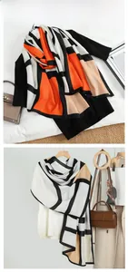 Detail of velvet scarf featuring color-block geometric patterns in orange, black, and beige