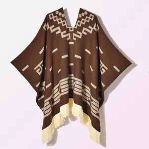 Detail of bohemian knit poncho with geometric jacquard patterns and tassel hem decor