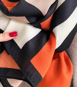 Close-up of herringbone weave velvet scarf with orange, beige and black geometric pattern