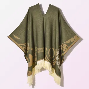 Detailed knit texture and olive green ethnic print with cream fringe on the poncho