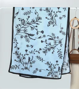 Detail of light blue floral velvet scarf with delicate black flower prints and narrow borders