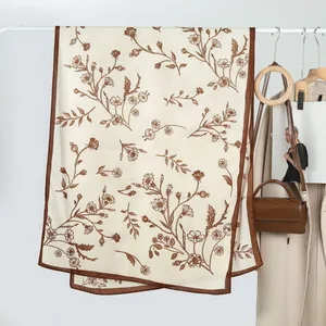 Detail of printed velvet scarf with brown floral patterns hanging on a rack