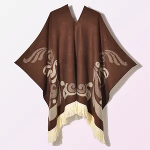Detailed knit texture and beige fringe trim on a dark brown bohemian poncho wrap
