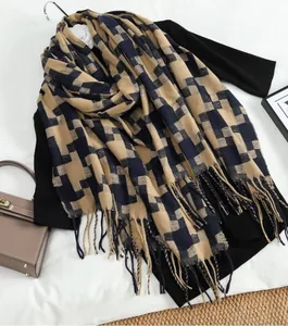 Close-up of khaki and navy houndstooth scarf featuring thick tassel fringe details