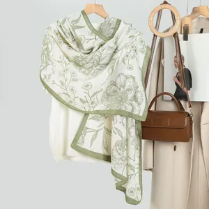 Blumenmuster Samtschal in Cremeweiß und Grün an einem weißen Pullover aufgehängt