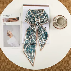 Detail van het paisley-patroon op een zijden blauwe sjaal geknoopt in een elegante strik