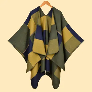 Close-up of geometric knit poncho shawl with olive green, navy, and mustard color blocks