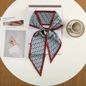 Detailopname van zijden twilly met geometrisch patroon gestrikt op een witte tafel