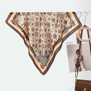 Detailed view of a vintage square scarf with star patterns and brown leather belt motifs