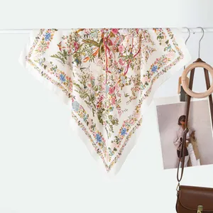 Detail of floral and bird print on a premium cream square silk scarf with nature patterns