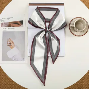 Detail van elegante zijdeachtige sjaal met beige en bruine geruite kleurvlakken