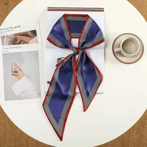Detail van elegante zijden sjaal met dambordpatroon op een witte tafel setting