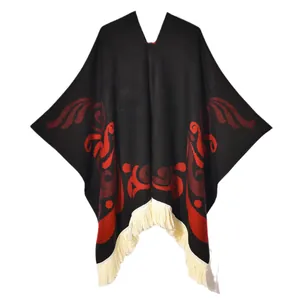 Ethnic knit poncho with vintage red totem patterns and white tassels on a black base