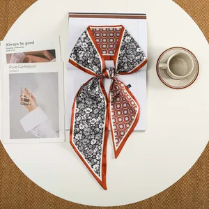 Detailopname van een elegante twilly sjaal met bloemenprint en geometrische sterren