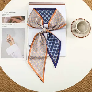 Detailweergave van een lange zijden sjaal met blauwe en oranje geometrische patronen