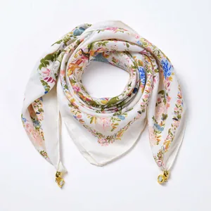 Close-up of floral velvet scarf featuring bird patterns and magnetic gold buckles