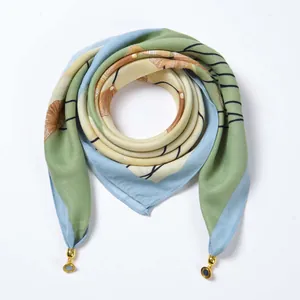 Detailed macro view of velvet scarf featuring herringbone texture and gold floral pendants