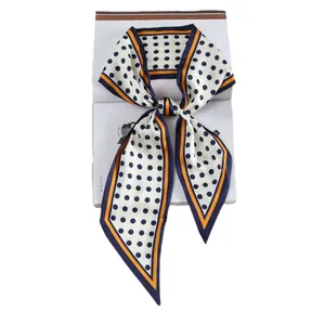 Zijden sjaal met polkadots en contrastrand geknoopt op een modetijdschrift