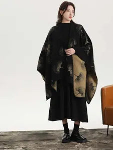 Detail of knit shawl featuring golden ginkgo leaf patterns on premium black fabric