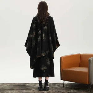 Rear view of black knit shawl cape with golden ginkgo leaf patterns and camel lining