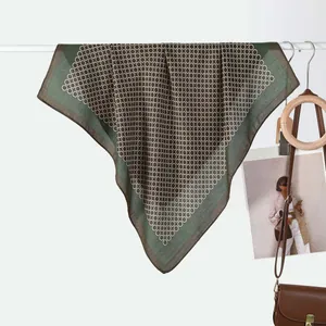 Detail of elegant silk scarf with green borders and chain link pattern draped stylishly