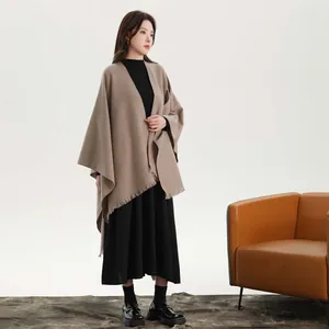 Detailed view of the thick knit shawl texture with delicate fringe and side ties