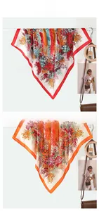 Close-up of lightweight floral silk scarves in red and orange with refined satin finish