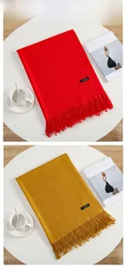 Detail view of red and yellow cashmere scarves with fringes and woven fabric texture