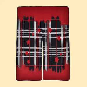 Dettaglio dello scialle in maglia con motivo plaid classico, stelle rosse ed effetto spray