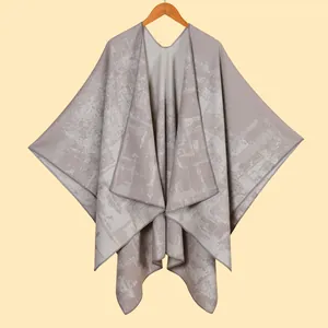 Detail of light grey jacquard poncho shawl with marble texture and V-neckline finish