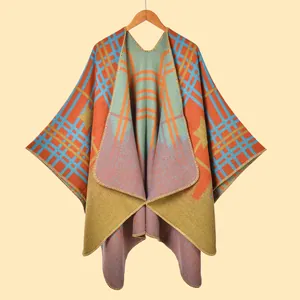Dettaglio della trama dello scialle in maglia con motivi geometrici arancioni e blu