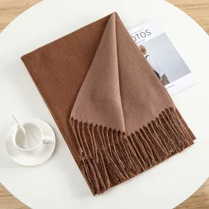 Close-up of caramel thick cashmere-like scarf with fringe details and soft texture