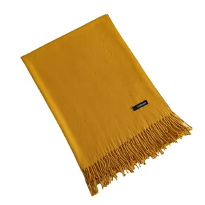 Soft ginger yellow cashmere scarf with elegant tassels on a clean white background