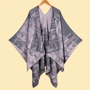 Detail view of the fine knit texture and jacquard pattern on a warm grey and lilac poncho shawl
