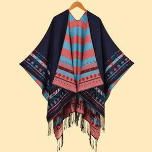 Détail du châle en tricot avec motifs géométriques colorés et bordures à franges noires
