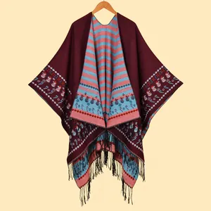 Détail d'un châle tricoté bordeaux avec motifs bonhommes de neige et franges noires