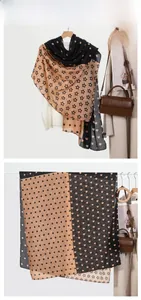 Detail view of cotton linen scarf showing heart patterns and polka dots in black and beige