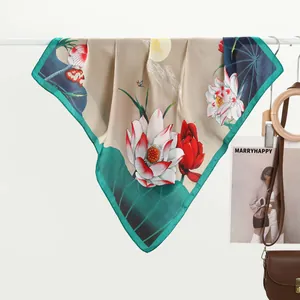 Close-up of elegant silk scarf with lotus and koi fish patterns on a wooden hanger