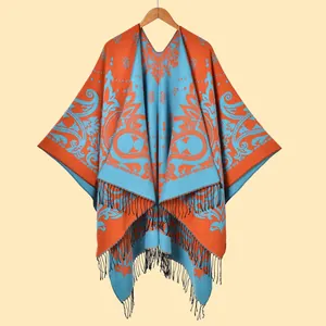 Λεπτομέρεια του σχεδίου paisley jacquard και μαύρα κρόσσια σε αυτή την πορτοκαλί εσάρπα