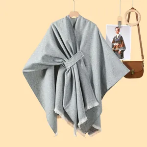 Detail eines dunkelgrauen Fransen-Ponchos mit Diagonalwebe und Taillenband