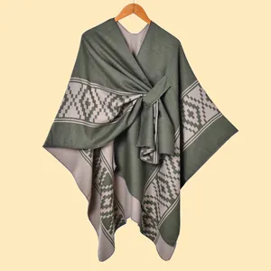 Dettaglio di scialle in maglia con motivi jacquard geometrici etnici verde e beige