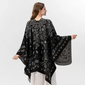 Detailed view of the vintage paisley pattern and floral motifs on the black shawl wrap