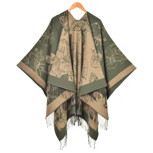 Women's floral knit poncho wrap in olive and khaki with fringe tassels on white background