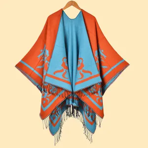 Knitted shawl wrap with orange and blue abstract jacquard pattern and fringe trim