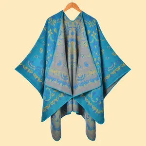 Detail view of ethnic blue poncho showing intricate paisley patterns and thick knit texture