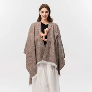 Detail der Bohème-Fransen und der braunen Tweed-Textur an einem stilvollen Damen-Poncho