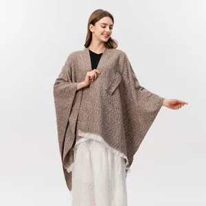 Detail eines braunen Fransenschals mit Seitentasche und weichem Strickgewebe