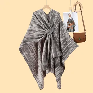 Detail of grey striped knit shawl wrap with a stylish twisted knot decoration