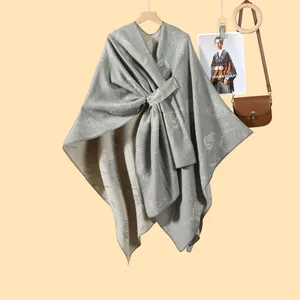 Dettaglio dello scialle jacquard grigio a rose con fibbia al collo e morbida maglia